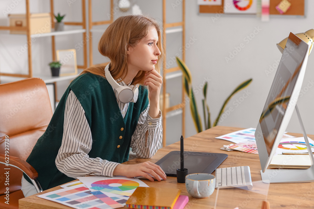 Female graphic designer working with computer at table in office