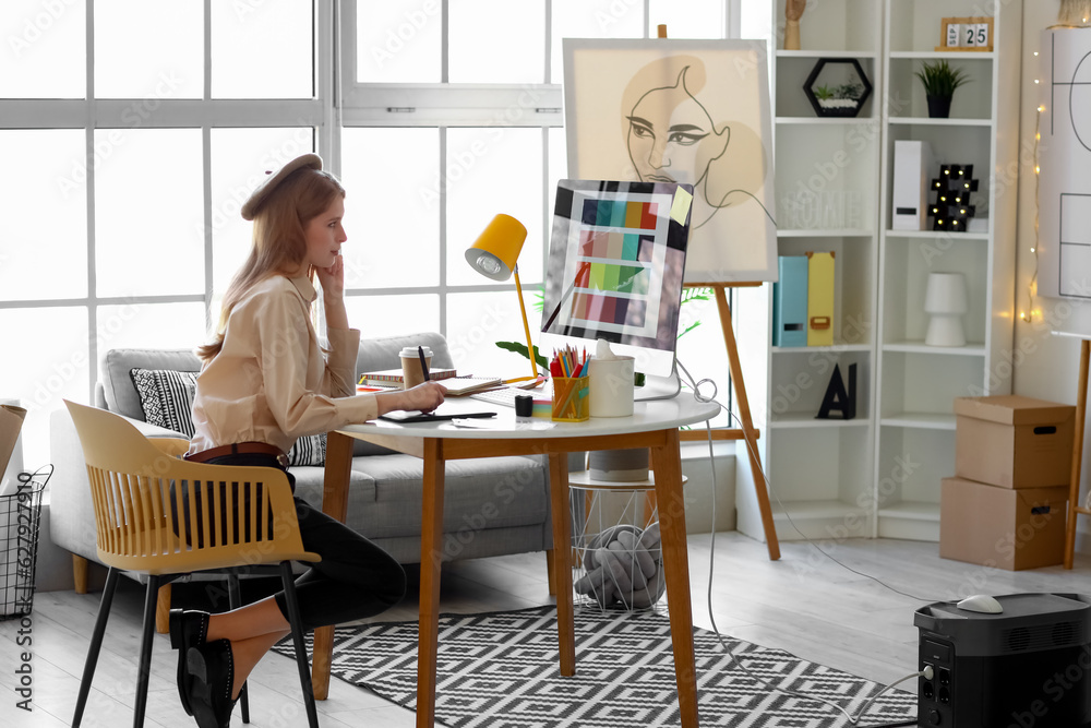 Female graphic designer working with tablet at table in office