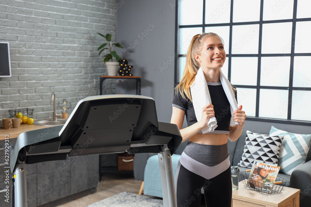 Sporty young woman after training on treadmill at home