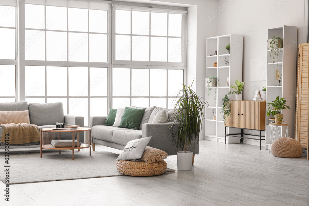 Interior of bright living room with cozy grey sofas and coffee table