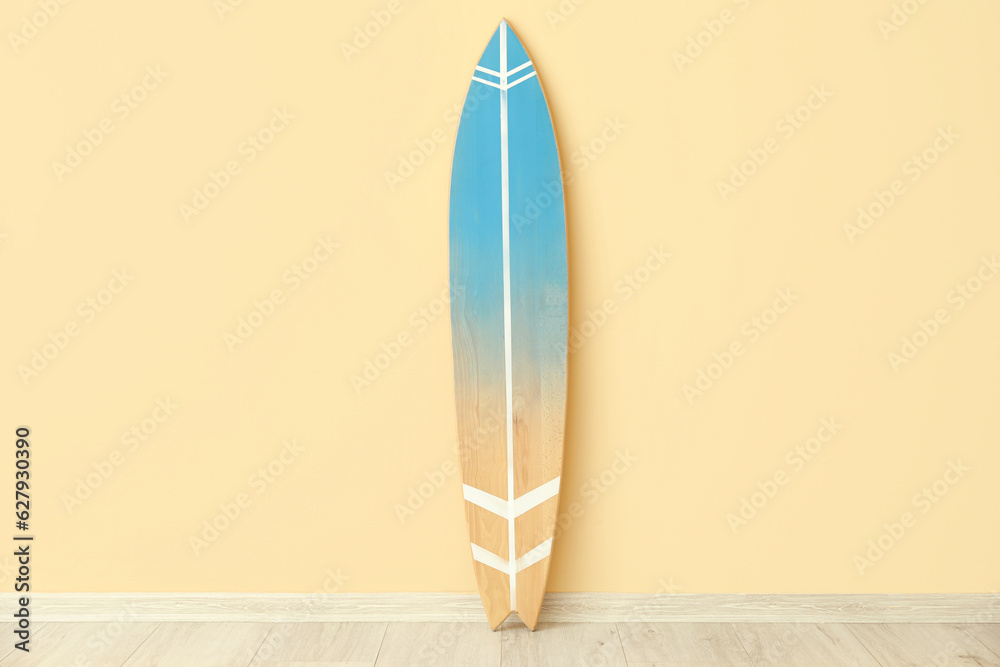 Wooden surfboard near beige wall