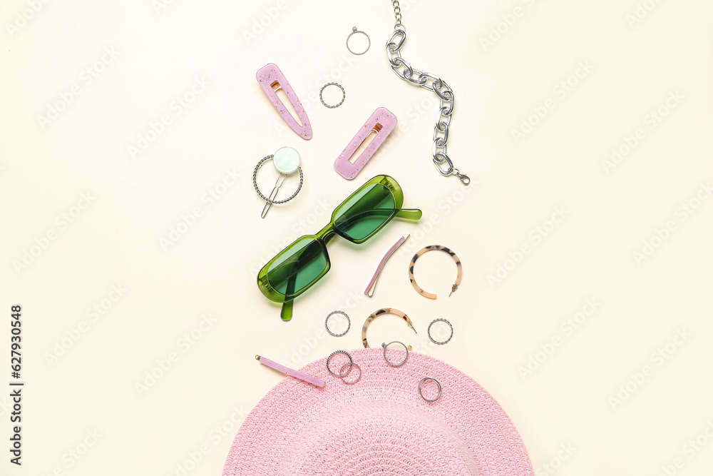 Stylish accessories with sunglasses and summer hat on light background