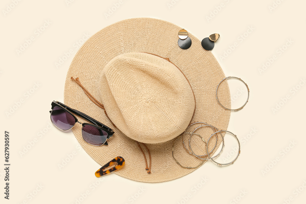 Stylish jewelry with sunglasses and summer hat on light background