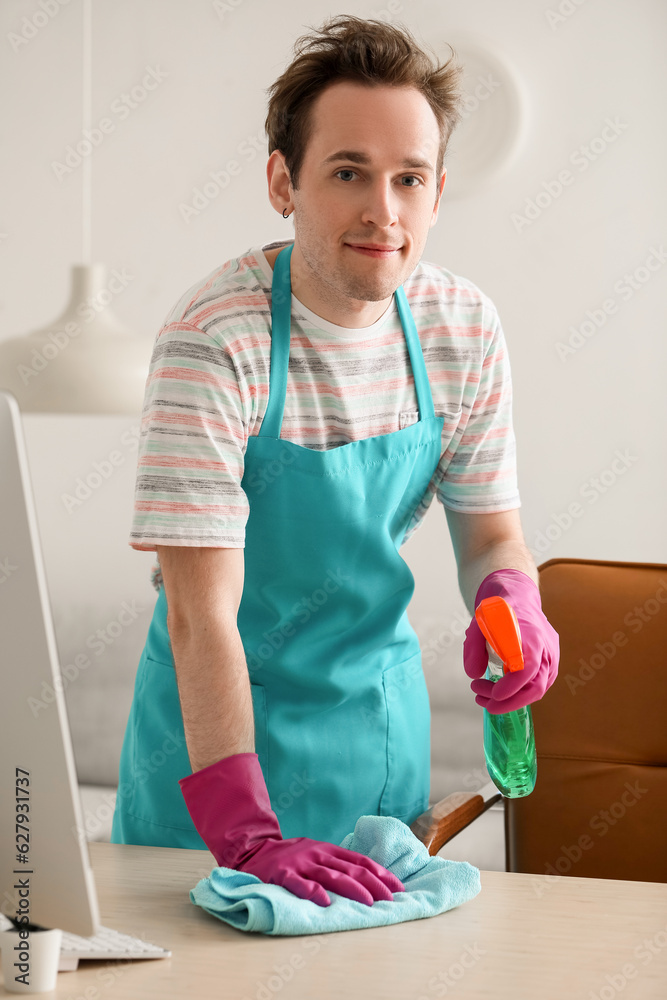 Young male janitor cleaning office