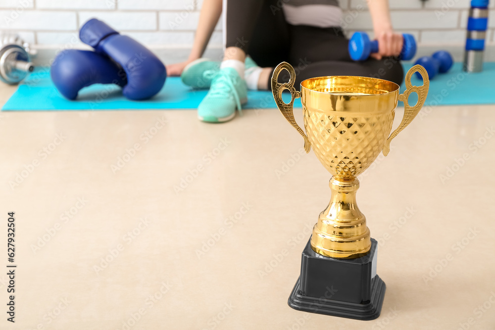 Gold cup on floor in gym, closeup