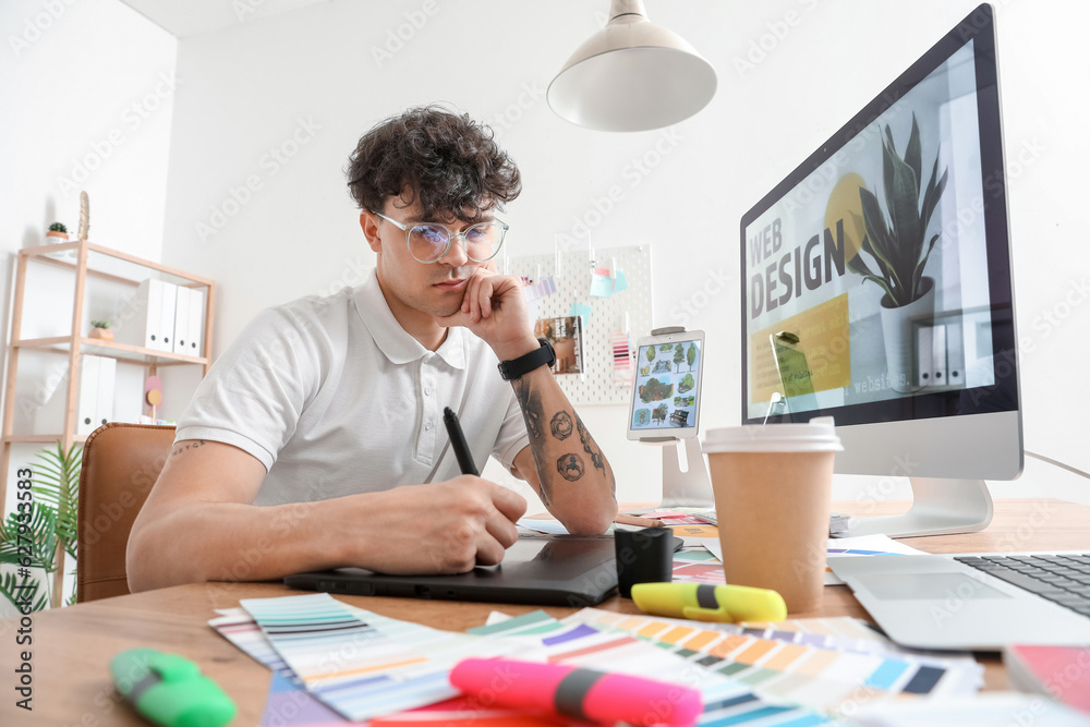 Male graphic designer working with tablet in office