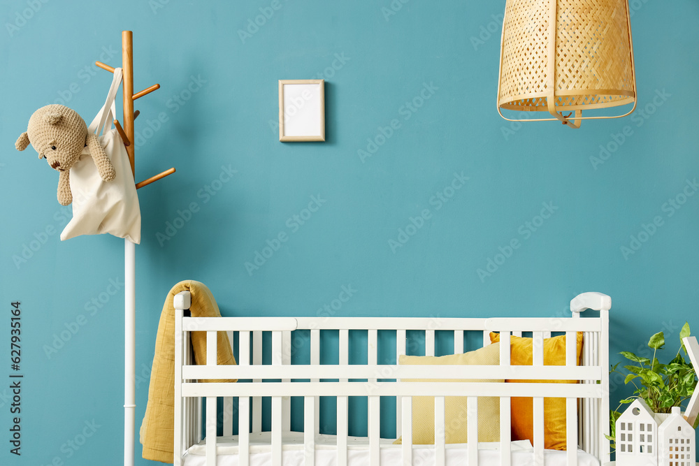 Interior of bedroom with baby crib and rack