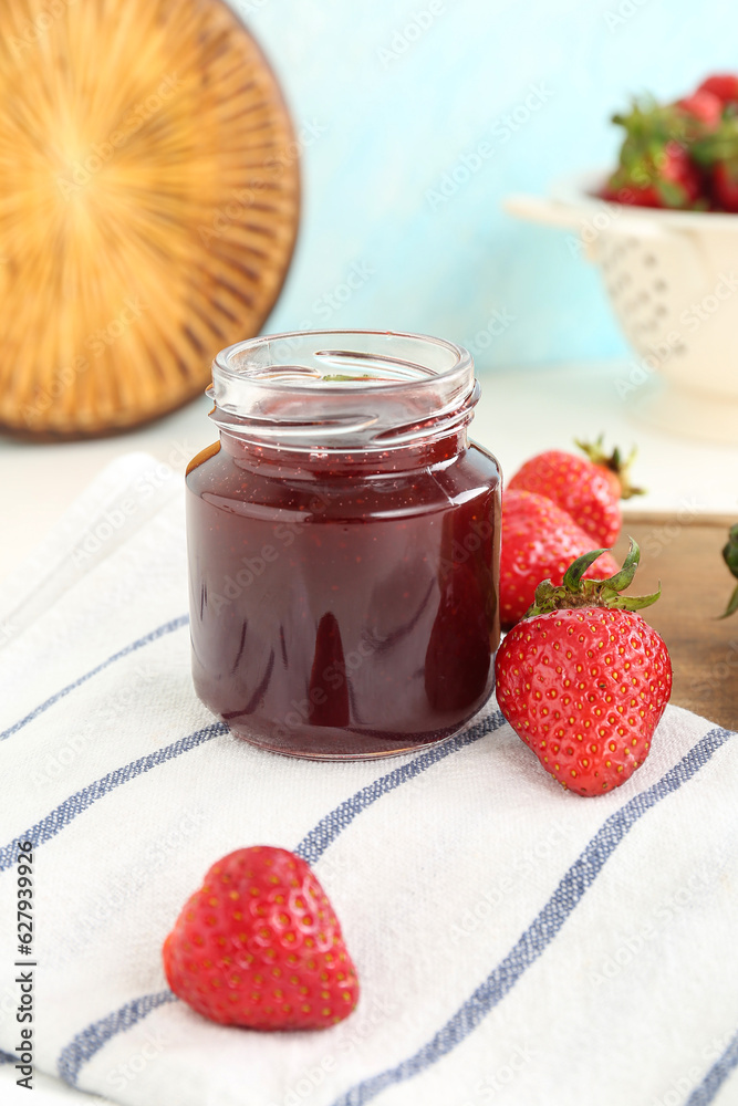 Jar of sweet strawberry jam on table