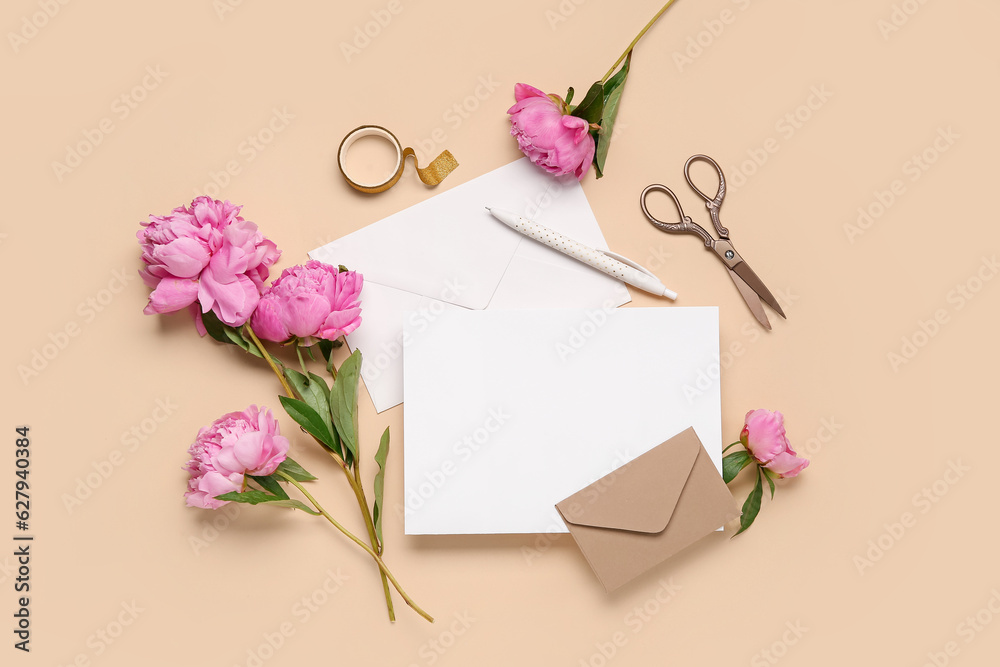 Composition with blank card, beautiful peony flowers, scissors and envelopes on color background