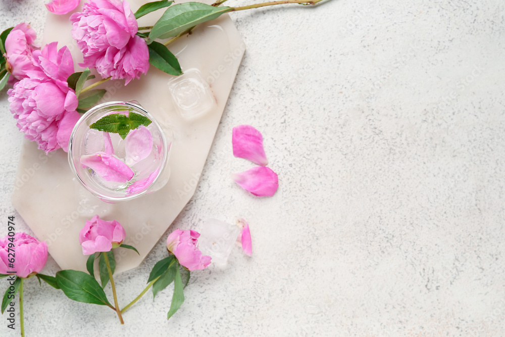 Composition with glass of water, ice cubes and beautiful peony flowers on light background