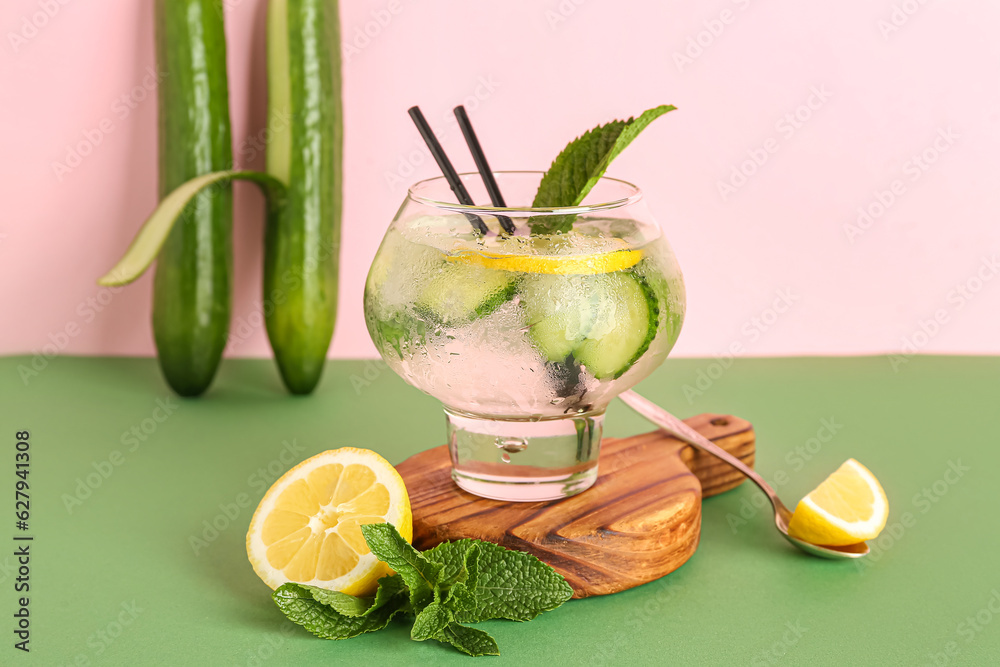 Glass of lemonade with cucumber and mint on colorful background