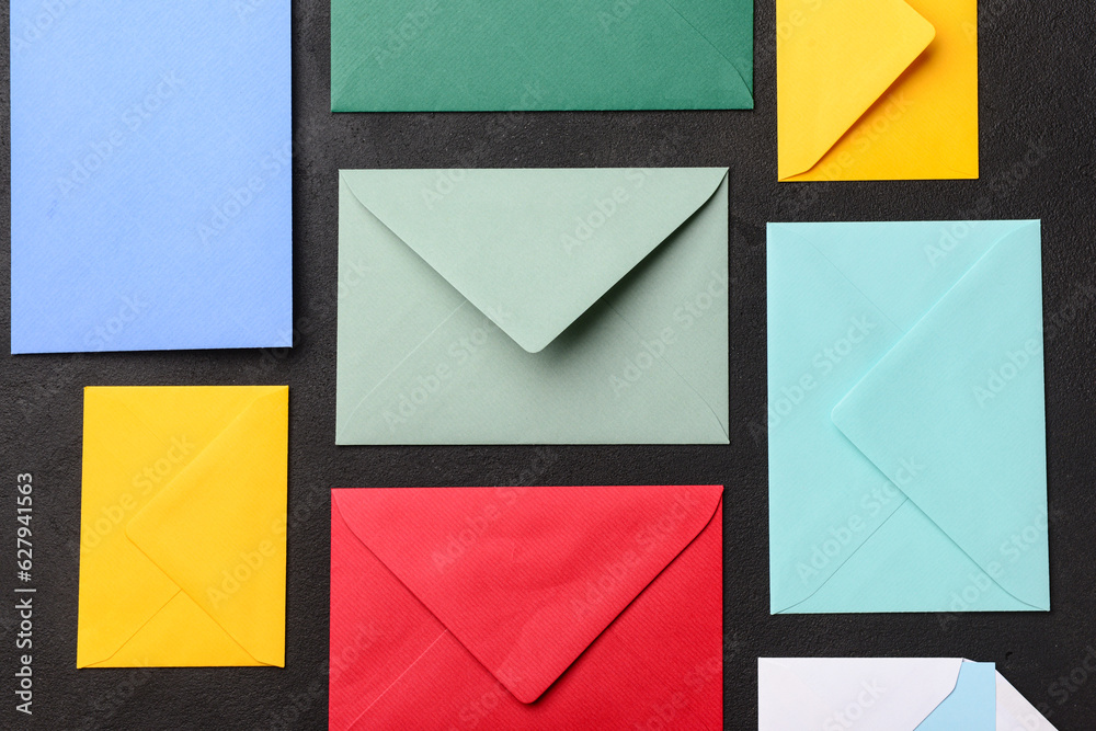 Composition with colorful envelopes on dark background, closeup