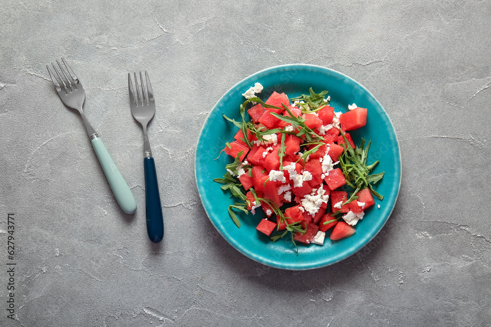 Plate of tasty watermelon salad on grey background