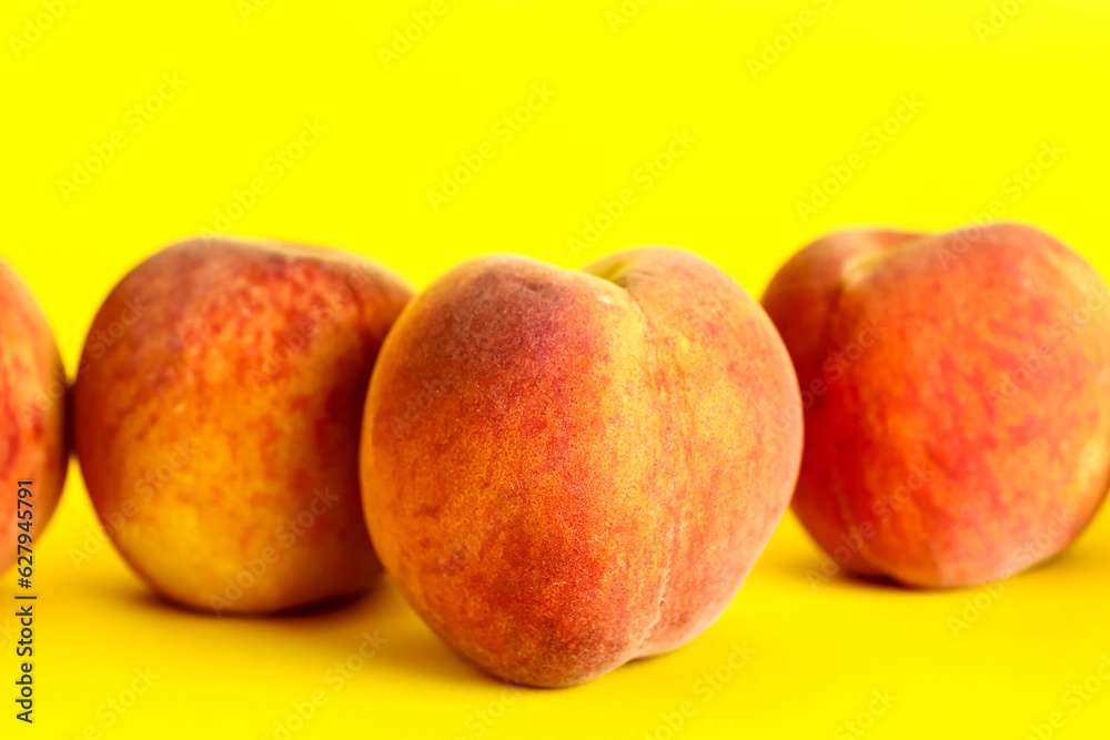 Sweet peaches on yellow background