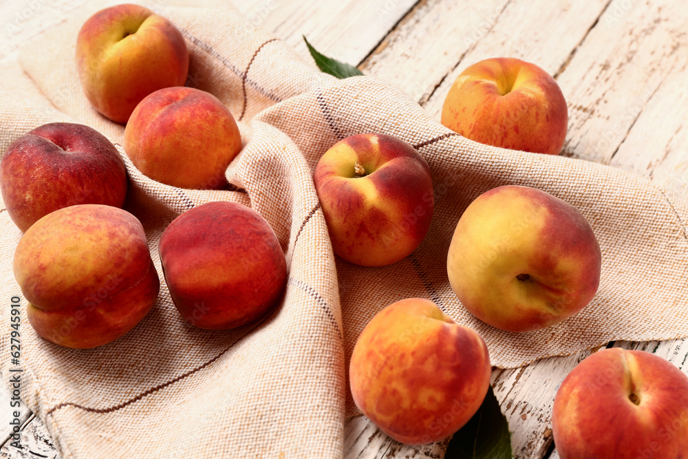 Many sweet peaches on white wooden background