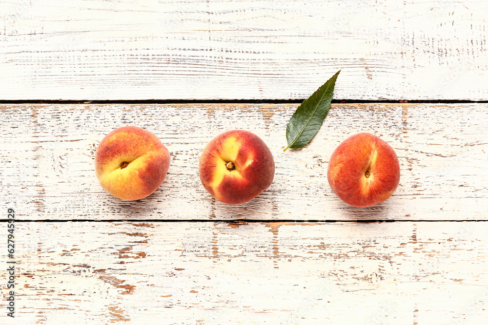 Sweet peaches on white wooden background