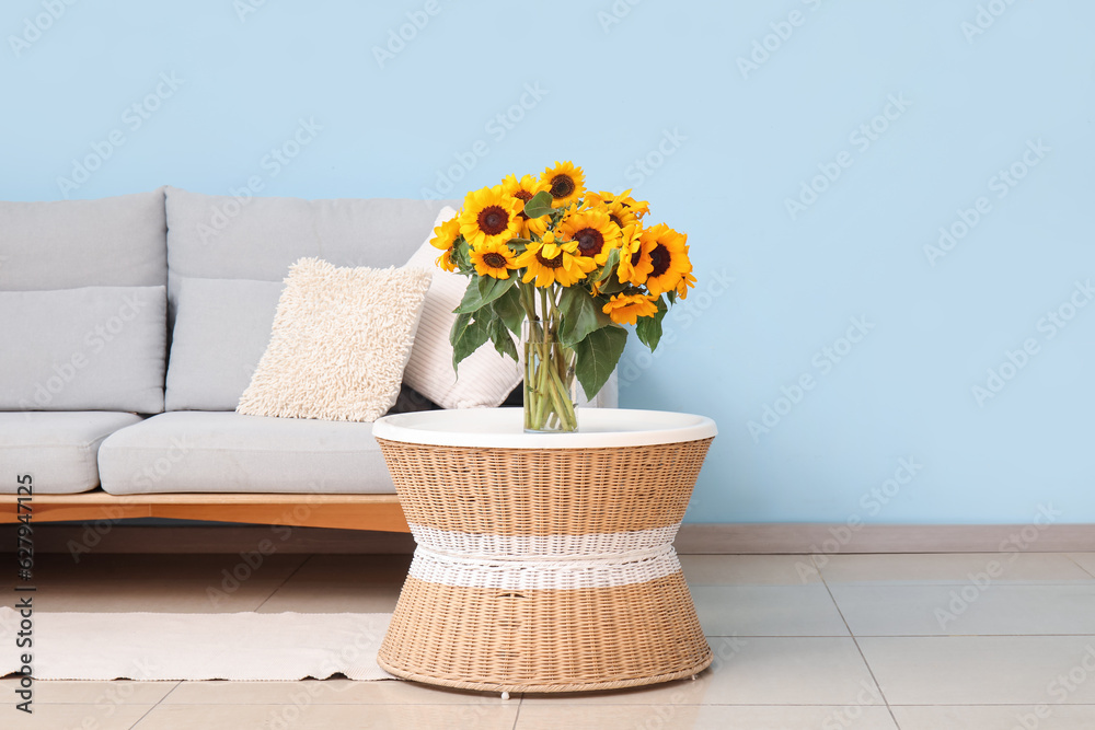 Vase with beautiful sunflowers on coffee table in living room