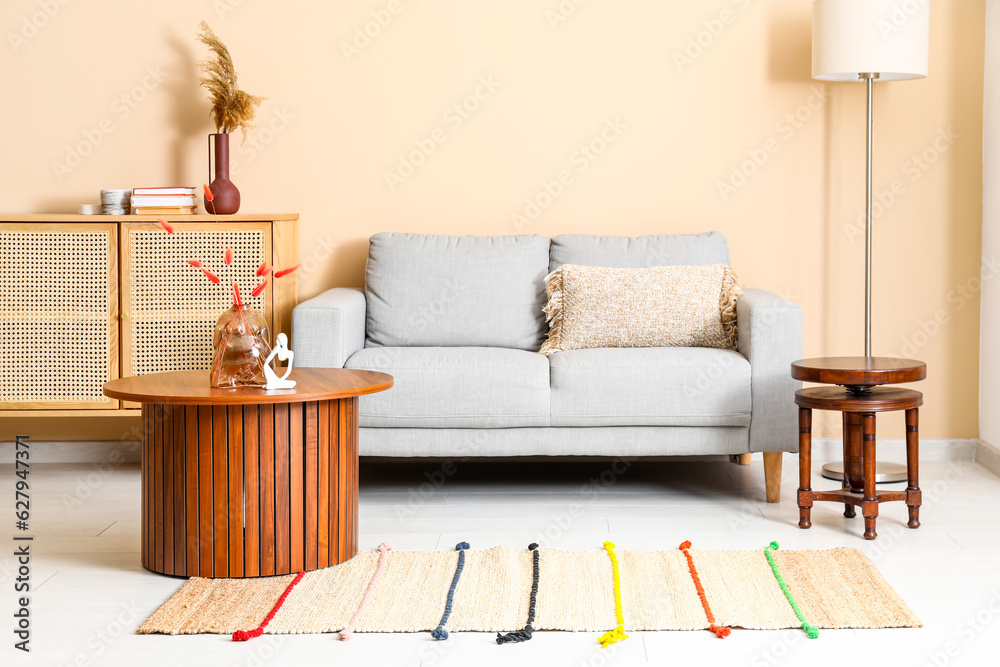 Interior of living room with grey sofa and stylish rug