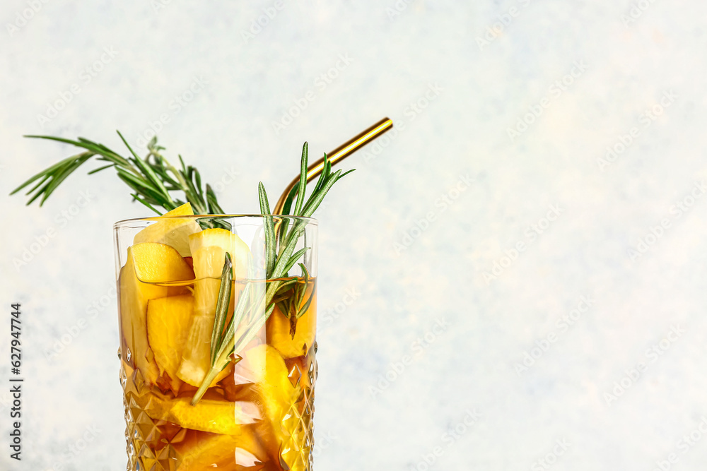 Glass of fresh peach lemonade with rosemary on white background