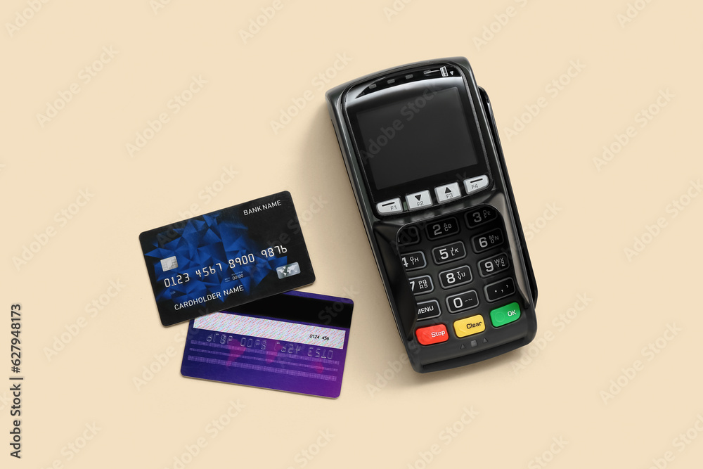 Payment terminal with credit cards on beige background