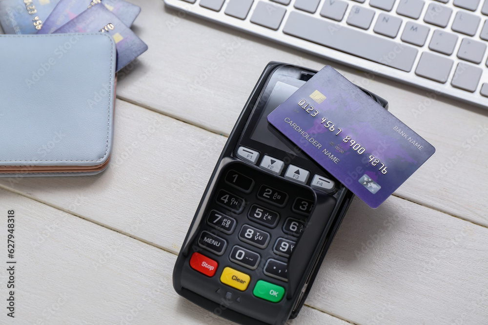 Keyboard with payment terminal, wallet and credit cards on white wooden background