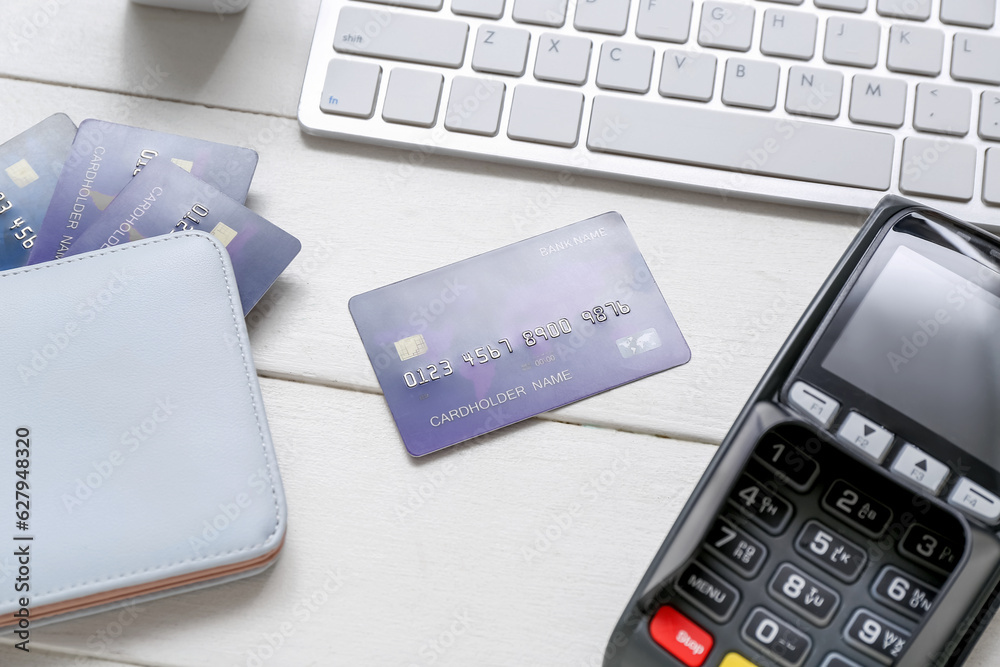 Keyboard with payment terminal, wallet and credit cards on white wooden background