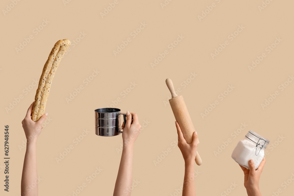 Female hands with baking utensils on beige background