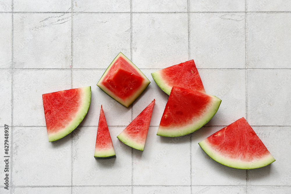 Pieces of fresh watermelon on white tile background