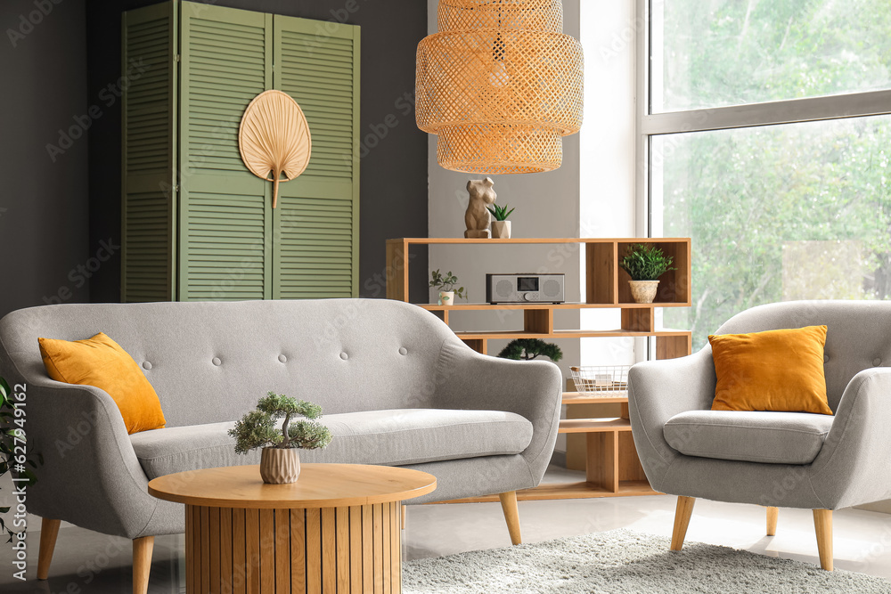 Interior of modern living room with grey sofa, armchair and wooden coffee table