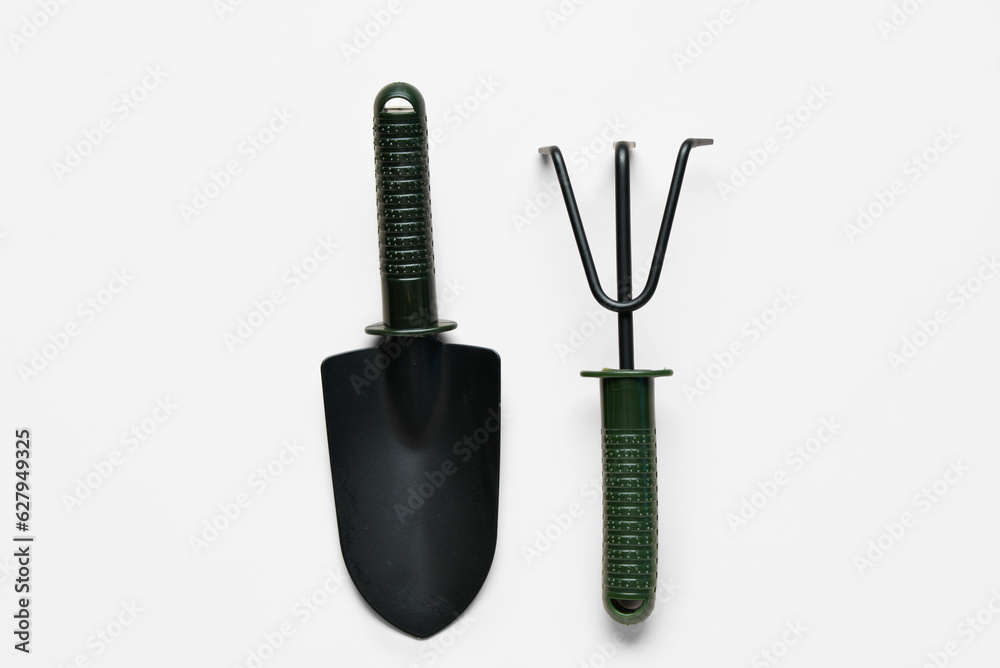 Gardening rake and shovel on white background