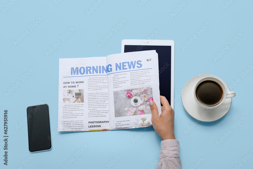 Woman reading newspaper with coffee and mobile phone on blue background