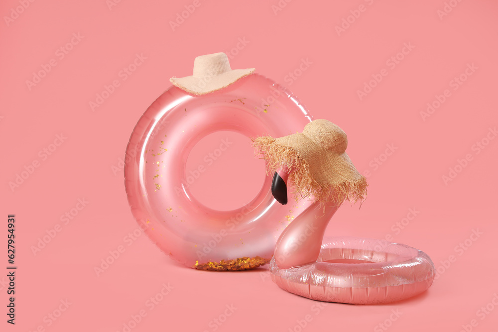 Inflatable rings and hats on pink background