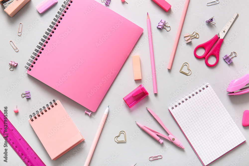 Different school stationery and notebooks on grey background