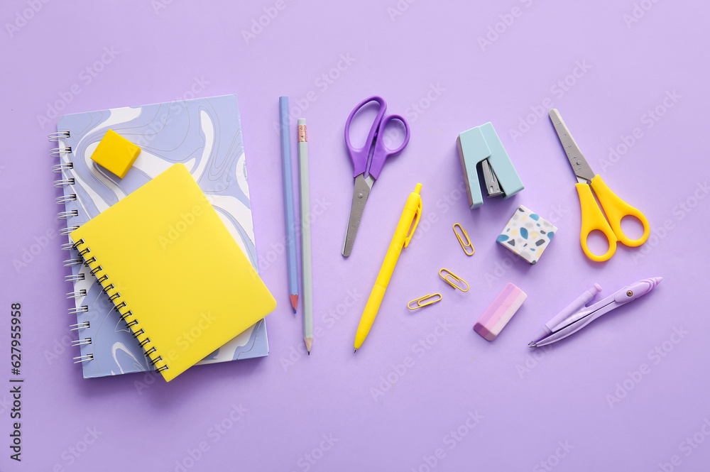 Different school stationery and notebooks on purple background