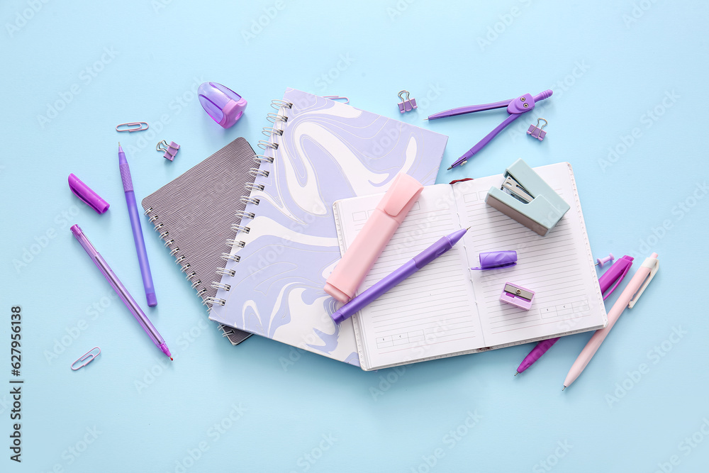 Different school stationery and notebooks on blue background