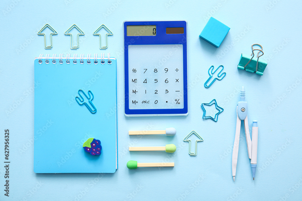 Different school stationery and notebook on blue background