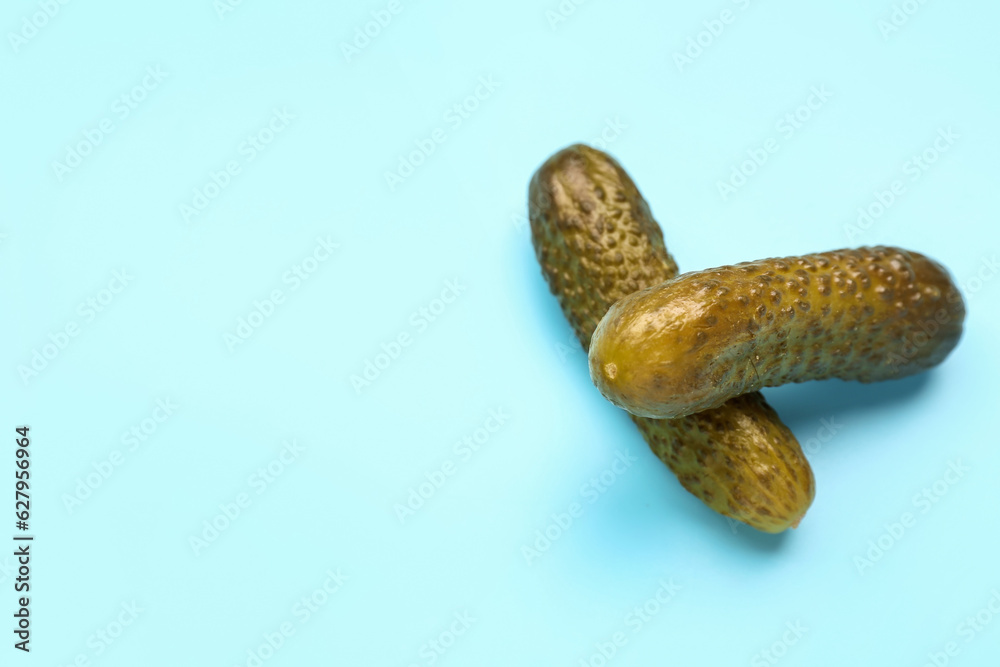 Pickled cucumbers on blue background