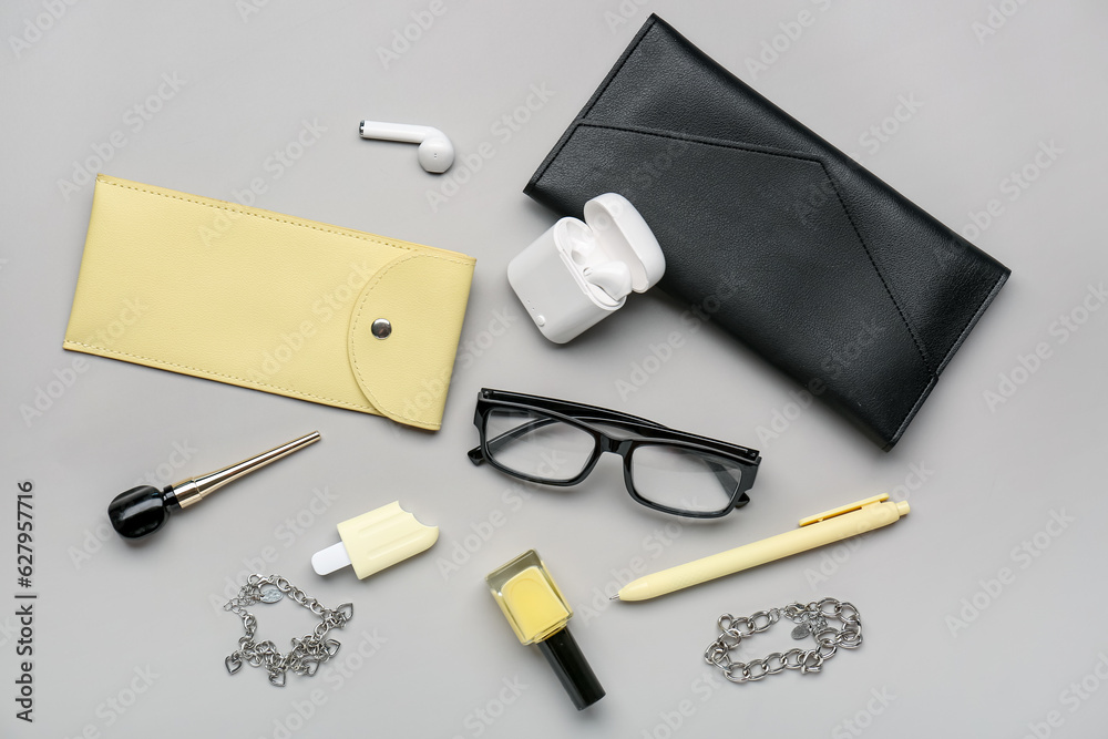 Stylish eyeglasses with stationery supplies and chain bracelets on grey background