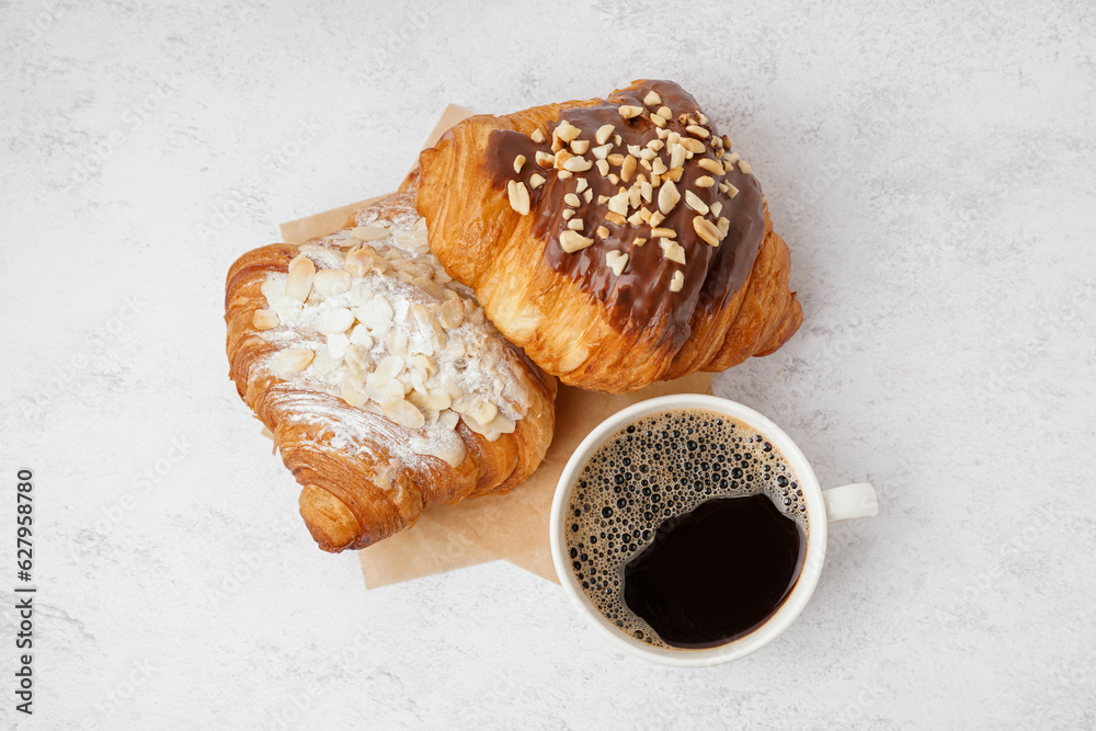 Different sweet croissants and cup of coffee on white background