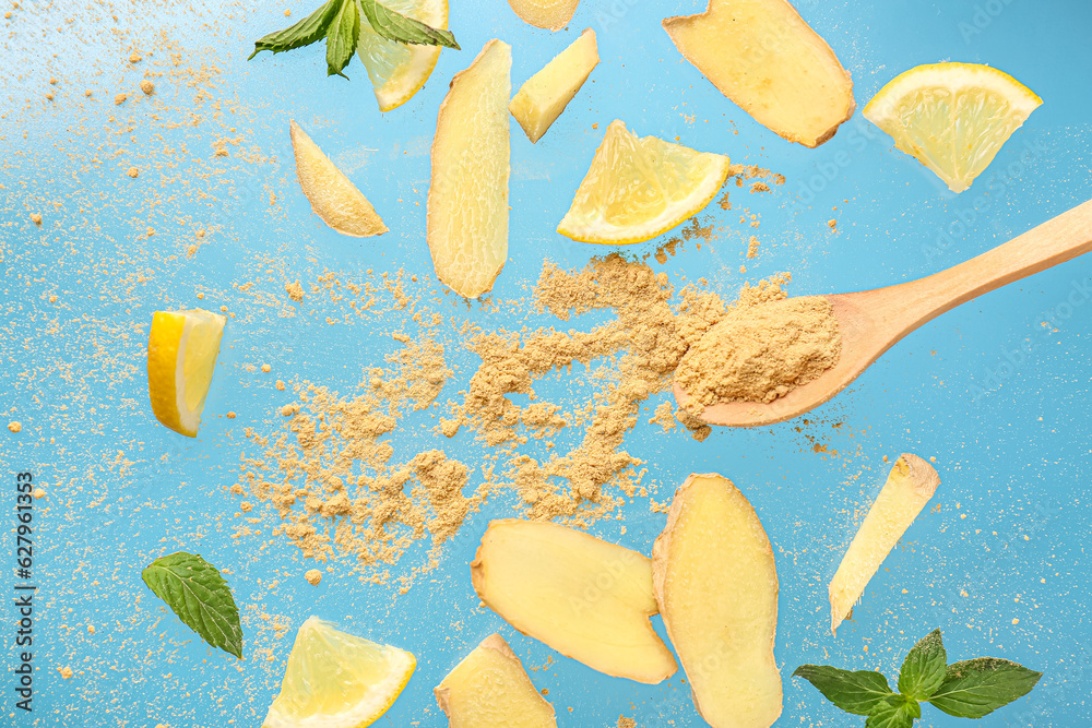 Slices of fresh ginger with dried powder and lemon on blue background