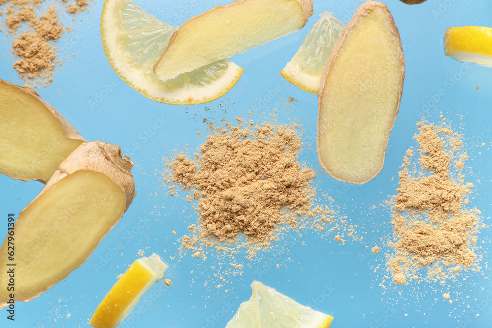 Slices of fresh ginger root with dried powder and lemon on blue background