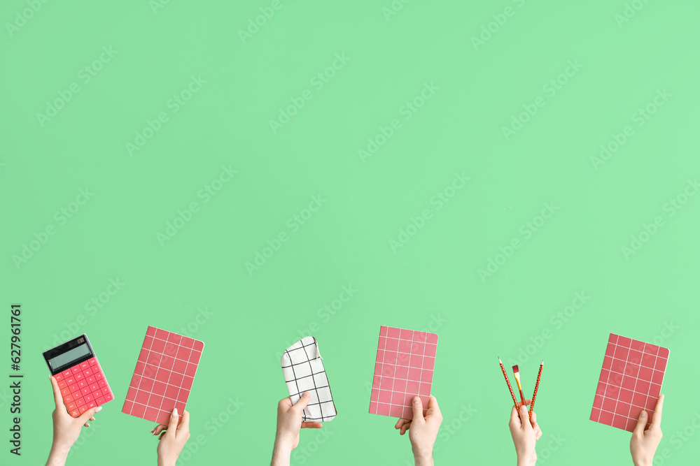 Hands with school accessories on green background