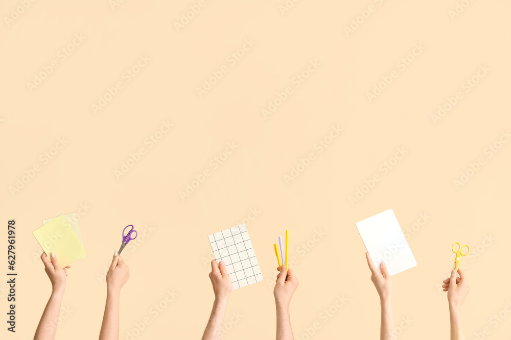 Hands with school supplies on beige background