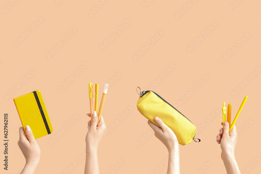 Female hands with school supplies on beige background