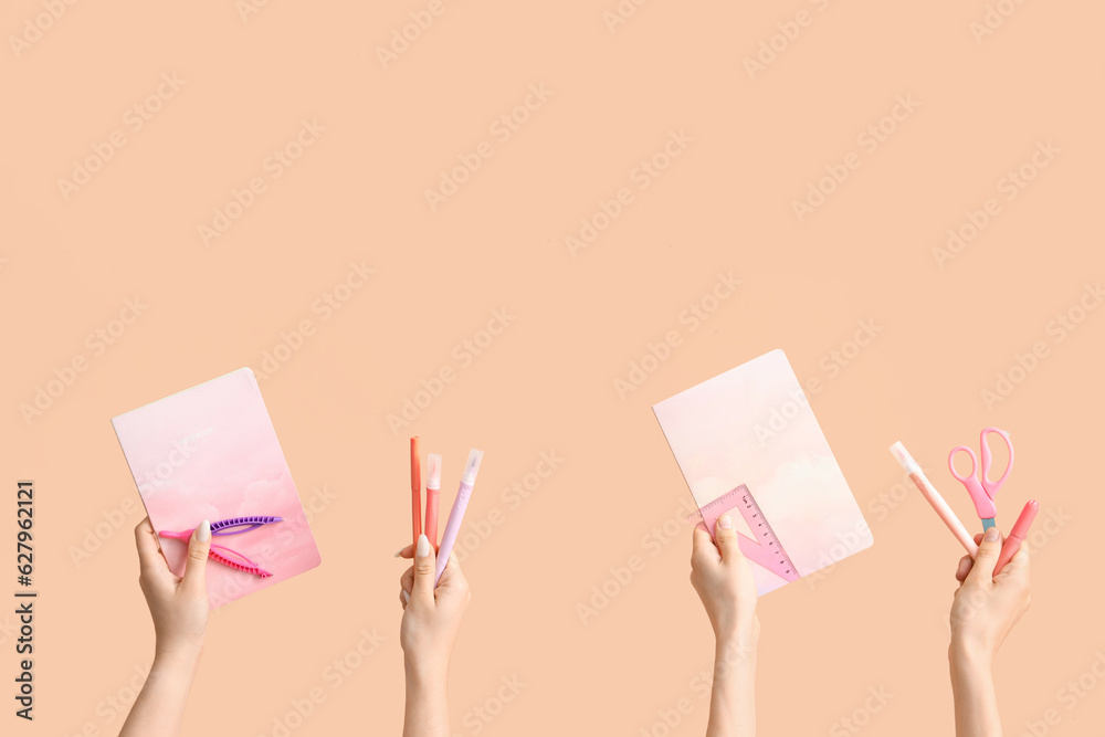 Female hands with school supplies on beige background