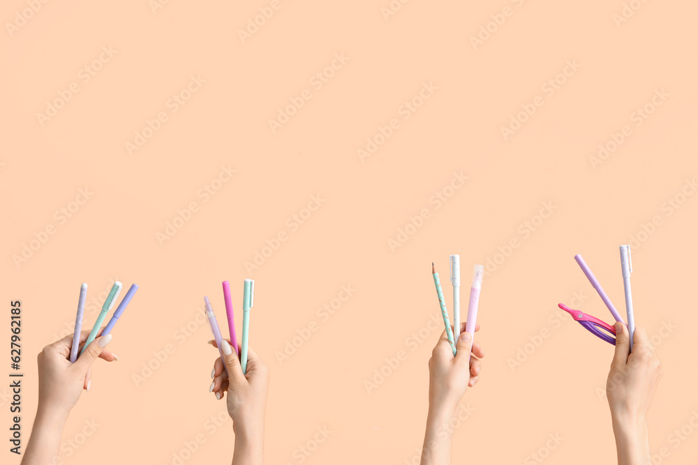 Female hands with school supplies on beige background