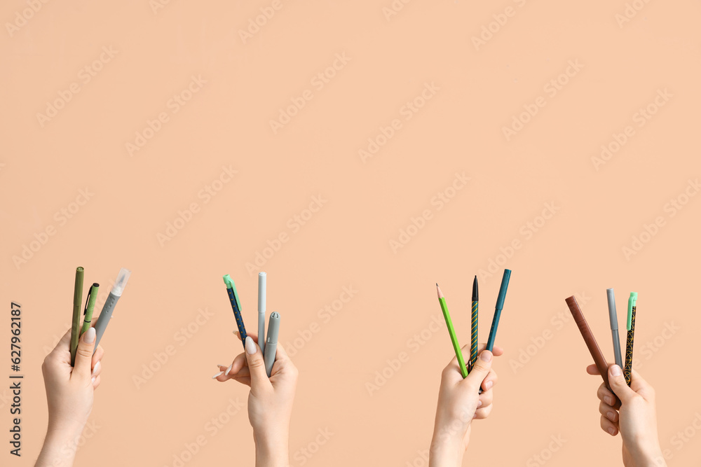 Female hands with school supplies on beige background