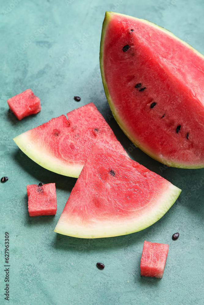 Composition with pieces of fresh ripe watermelon on green background, closeup