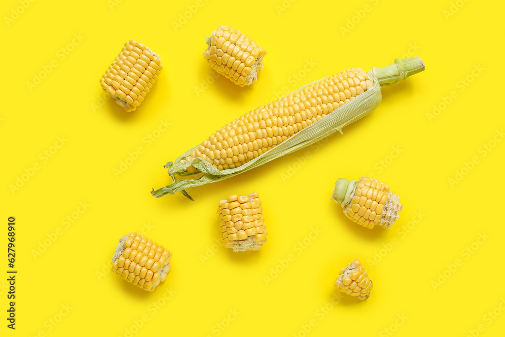 Cut and whole corn cobs on yellow background