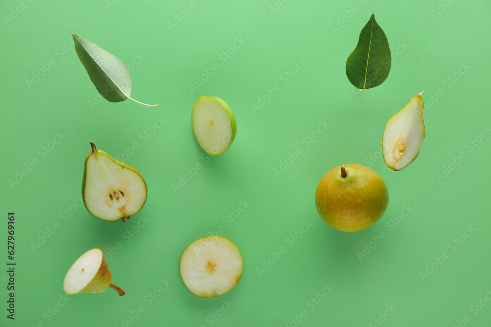 Flying ripe pears on green background